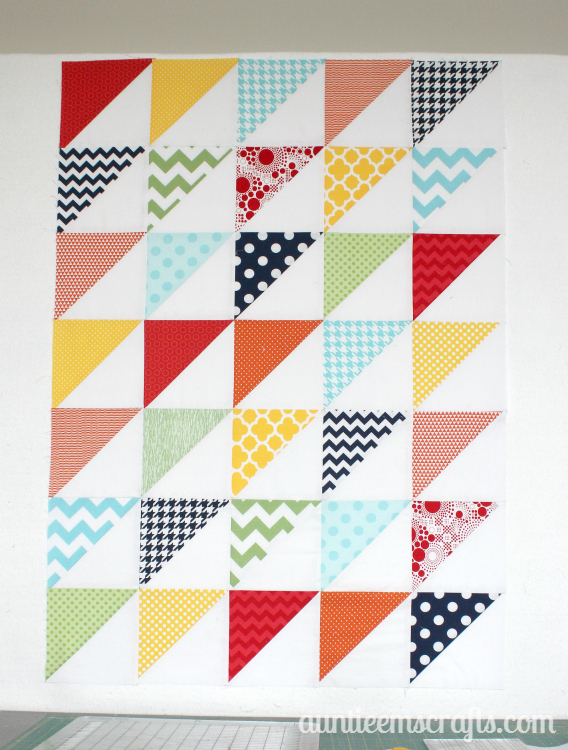Rainbow Half Square Triangle Quilt. This rainbow HST (half square triangle) quilt came together in just one day.  You, too, can make one quickly with scraps or even a layer cake.| Auntie Em's Crafts