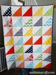 Rainbow Half Square Triangle Quilt. This rainbow HST (half square triangle) quilt came together in just one day. You, too, can make one quickly with scraps or even a layer cake.| Auntie Em's Crafts